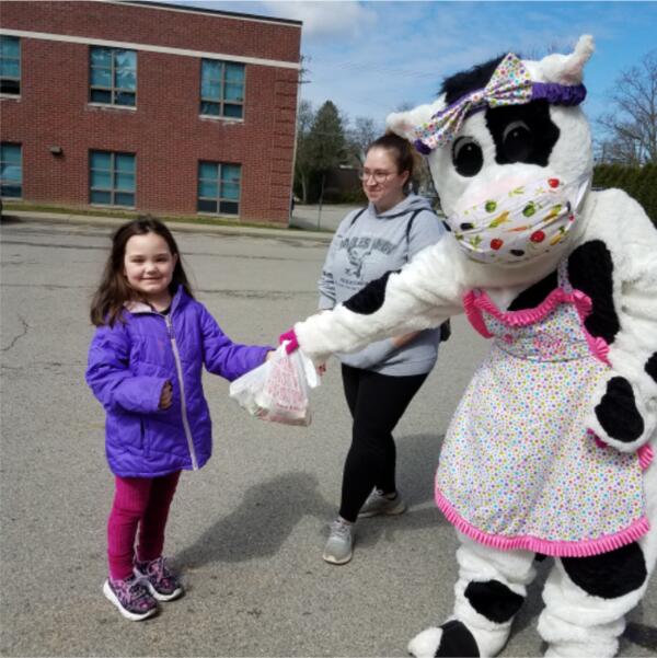 Molly the Cow helps hand out lunches during virtual instruction!